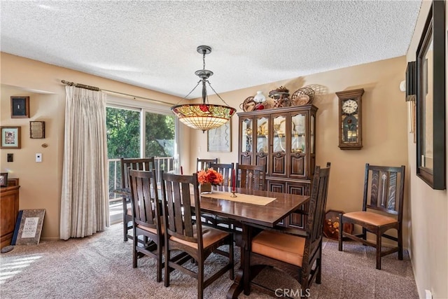 carpeted dining area with a textured ceiling