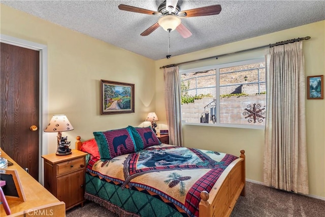 bedroom featuring ceiling fan, dark carpet, and a textured ceiling