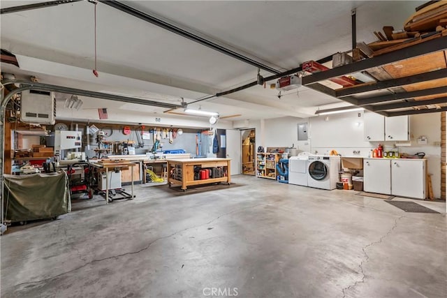 garage featuring electric panel, washer and clothes dryer, a garage door opener, and a workshop area