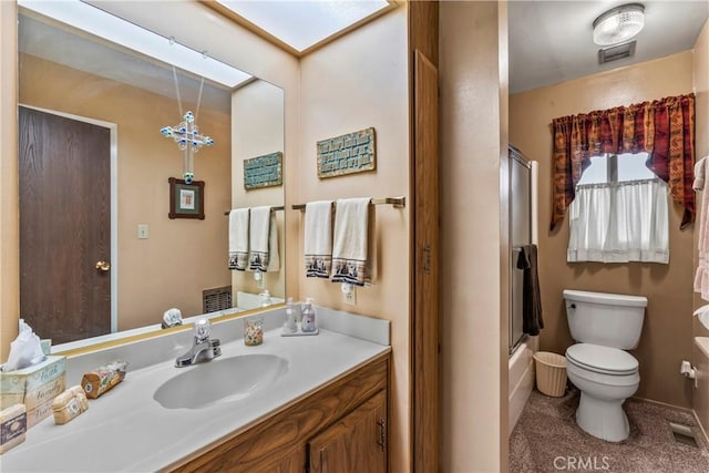 full bathroom featuring toilet, combined bath / shower with glass door, and vanity