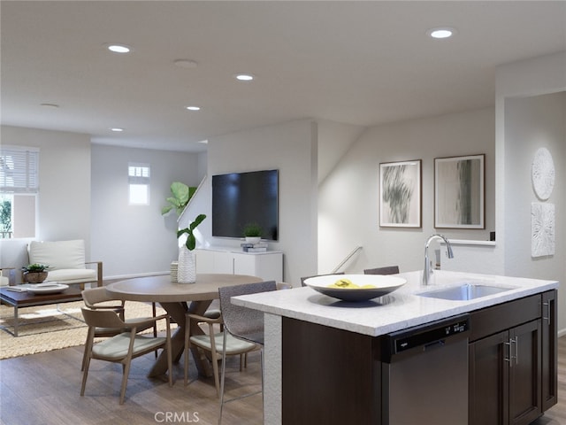 kitchen with hardwood / wood-style flooring, dishwasher, an island with sink, dark brown cabinets, and sink