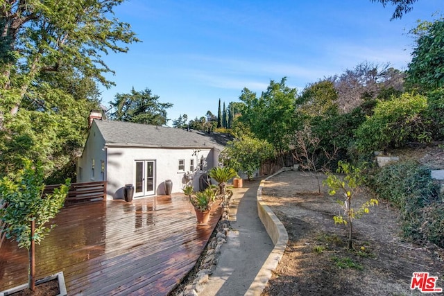 back of property with a deck and french doors