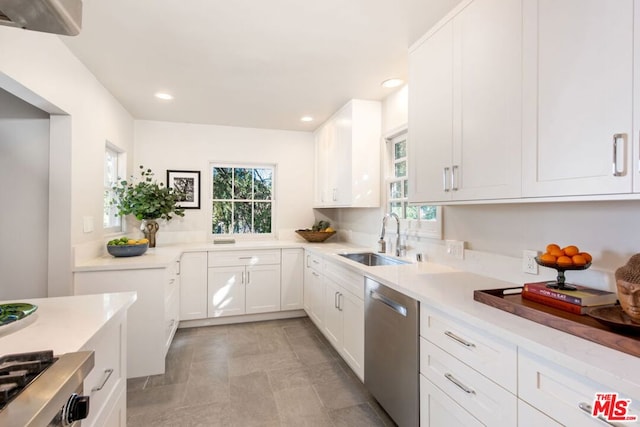 kitchen featuring sink, white cabinets, stainless steel dishwasher, and light stone counters