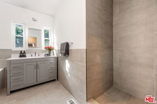 bathroom featuring tile walls, tile patterned flooring, and vanity