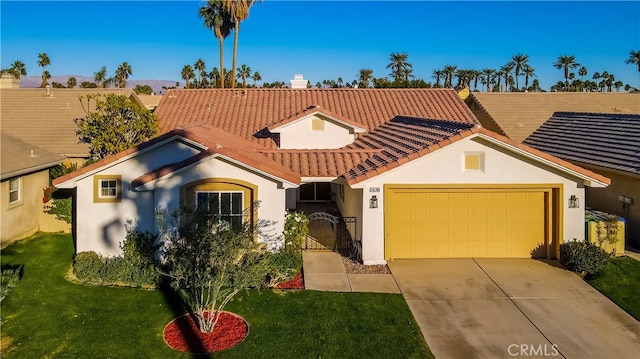 mediterranean / spanish-style home with a garage and a front lawn