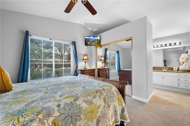 carpeted bedroom with sink, ceiling fan, connected bathroom, and vaulted ceiling