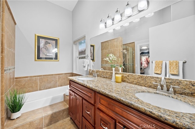 bathroom with independent shower and bath, tile patterned floors, and vanity