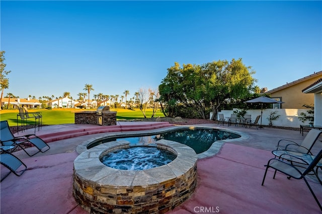 view of swimming pool with exterior kitchen, a patio, a yard, and an in ground hot tub