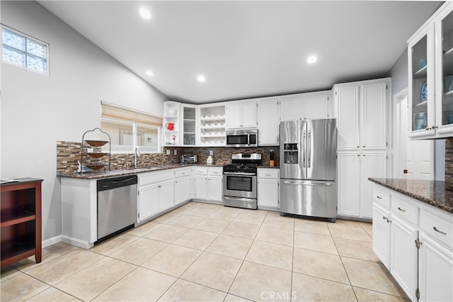 kitchen featuring white cabinetry, backsplash, dark stone counters, and appliances with stainless steel finishes