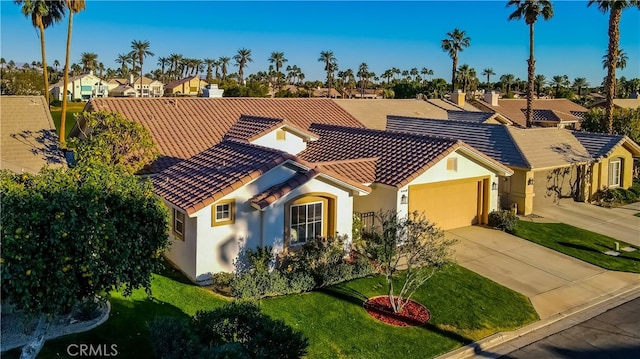 mediterranean / spanish house featuring a front lawn and a garage