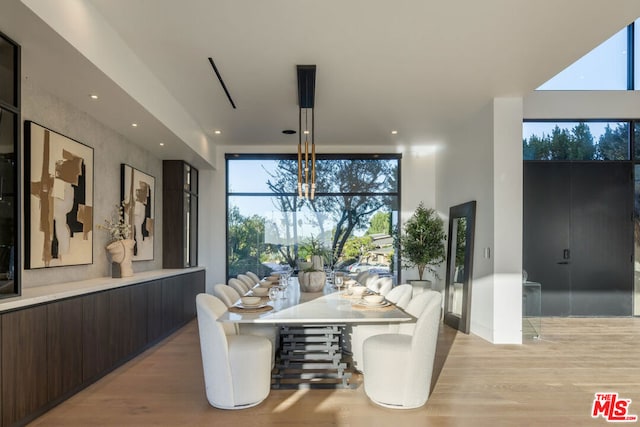 dining space featuring light hardwood / wood-style flooring and an inviting chandelier