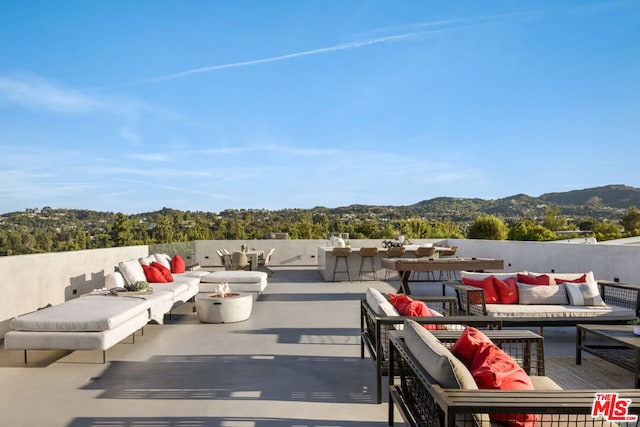 view of patio / terrace featuring an outdoor living space with a fire pit and a mountain view