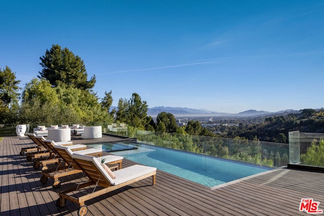 view of pool featuring a deck with mountain view