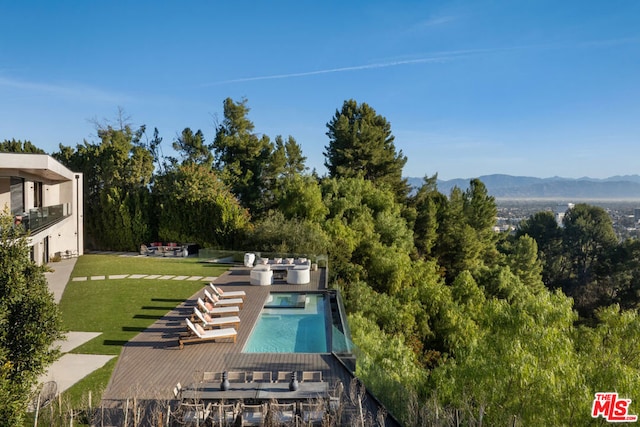 view of pool featuring a lawn and a mountain view