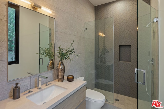 bathroom featuring tile walls, toilet, walk in shower, and vanity