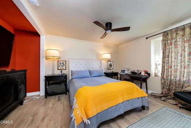 bedroom featuring ceiling fan, baseboards, crown molding, and wood finished floors