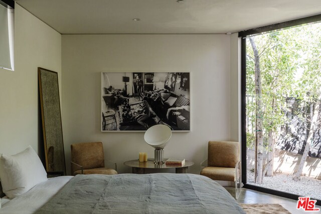 bedroom featuring floor to ceiling windows and concrete floors