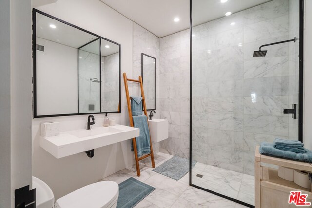 bathroom featuring toilet and a tile shower