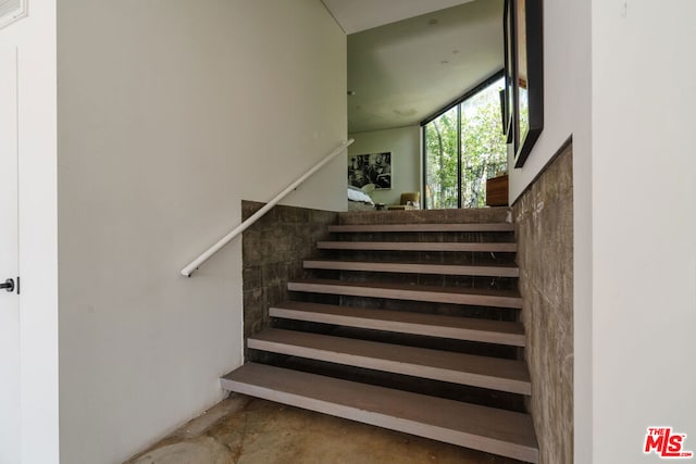 staircase with concrete flooring