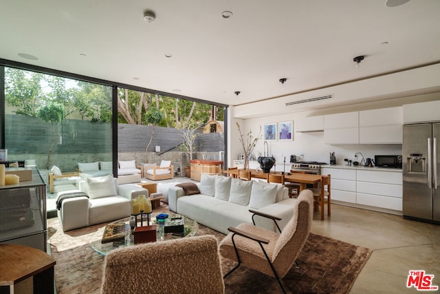 living room featuring expansive windows and sink