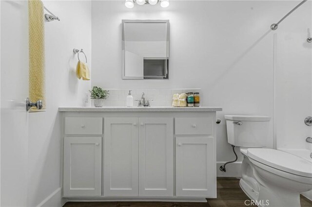 full bathroom with toilet, vanity, wood-type flooring, and shower / washtub combination