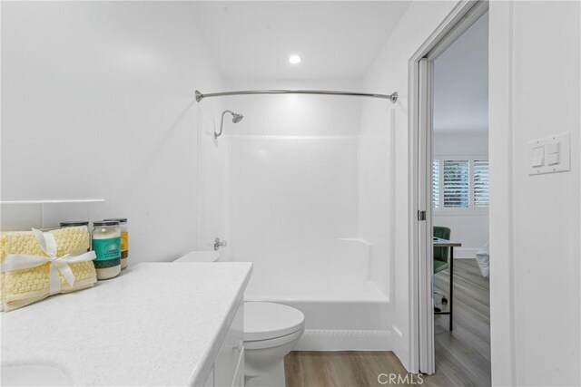 full bathroom featuring toilet, vanity, shower / bath combination, and hardwood / wood-style flooring