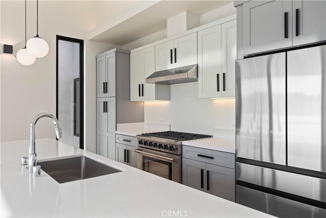 kitchen featuring decorative light fixtures, appliances with stainless steel finishes, gray cabinets, and sink