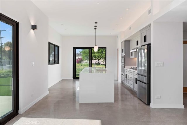 kitchen with gray cabinets, appliances with stainless steel finishes, hanging light fixtures, plenty of natural light, and sink