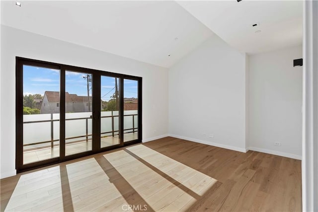 spare room with lofted ceiling and hardwood / wood-style floors