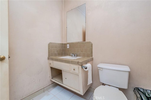 bathroom featuring toilet, tile patterned flooring, vanity, and tasteful backsplash