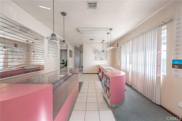 kitchen with decorative light fixtures, ceiling fan, light tile patterned floors, and a center island