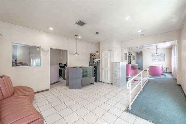 kitchen with hanging light fixtures and light carpet