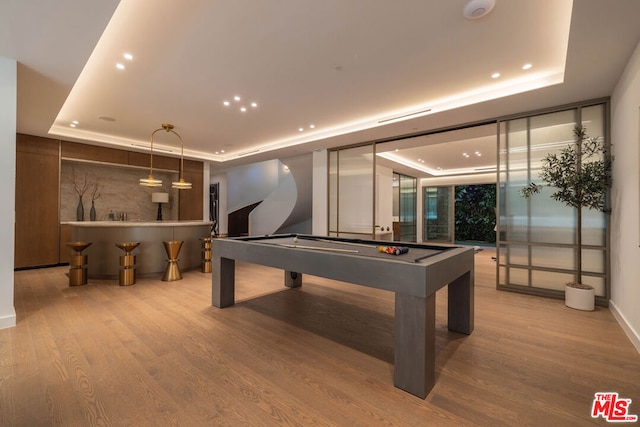 rec room featuring pool table, light hardwood / wood-style flooring, and a raised ceiling