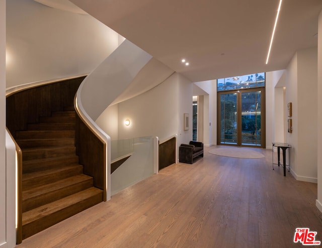 staircase featuring hardwood / wood-style flooring and expansive windows