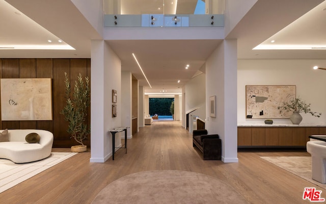 corridor with light hardwood / wood-style floors and a high ceiling