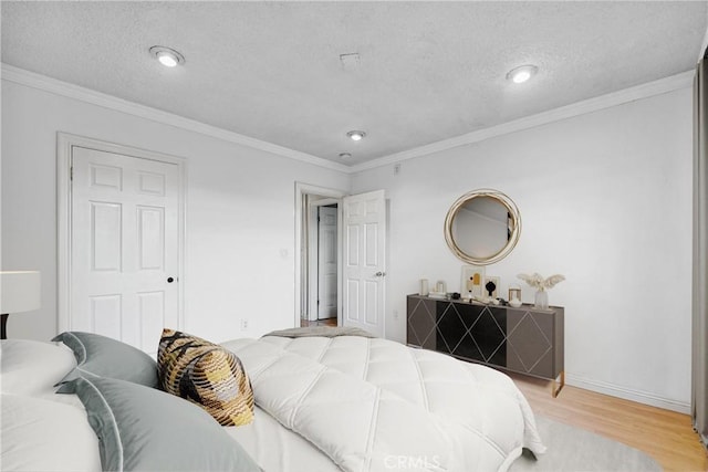 bedroom with light wood-type flooring, crown molding, and a textured ceiling