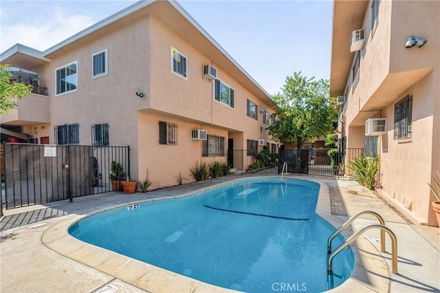 view of swimming pool with a wall mounted air conditioner