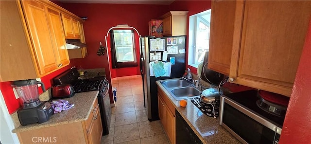 kitchen with stainless steel appliances, light tile patterned flooring, sink, and a wealth of natural light