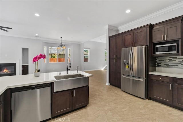 kitchen with sink, ornamental molding, backsplash, dark brown cabinetry, and appliances with stainless steel finishes