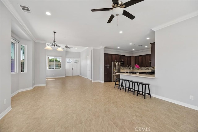 living room with ornamental molding and ceiling fan