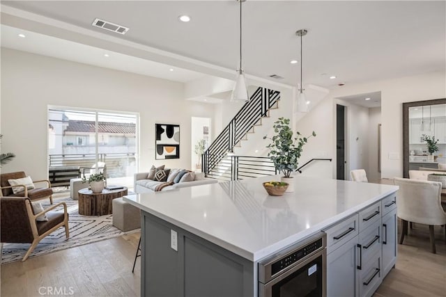 1700 Perkins Ln, Redondo Beach, CA 90278 - kitchen with open floor plan, light wood-style floors, gray cabinetry, a kitchen island, and recessed lighting