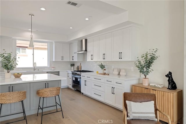 1700 Perkins Ln, Redondo Beach, CA 90278 - kitchen featuring appliances with stainless steel finishes, wall chimney range hood, a kitchen breakfast bar, decorative backsplash, and light countertops