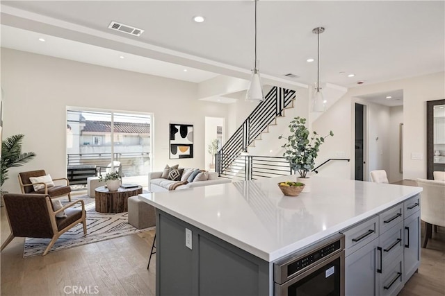 1700 Perkins Ln, Redondo Beach, CA 90278 - kitchen featuring open floor plan, gray cabinetry, light wood finished floors, a center island, and light countertops