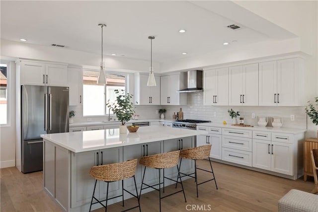 1700 Perkins Ln, Redondo Beach, CA 90278 - kitchen with appliances with stainless steel finishes, wall chimney exhaust hood, a kitchen island, white cabinetry, and recessed lighting