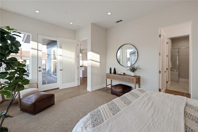 bedroom with access to exterior, light hardwood / wood-style floors, and ensuite bath