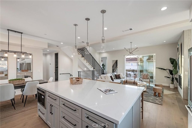 kitchen featuring light wood-type flooring, a kitchen island, and pendant lighting