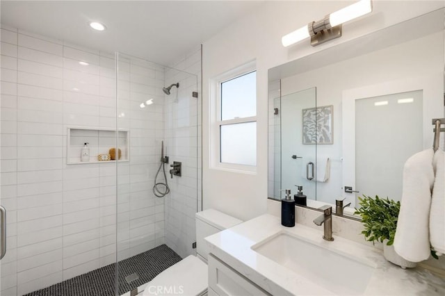 bathroom with an enclosed shower, vanity, and toilet