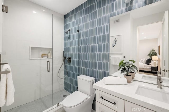 bathroom with toilet, vanity, and a shower with door