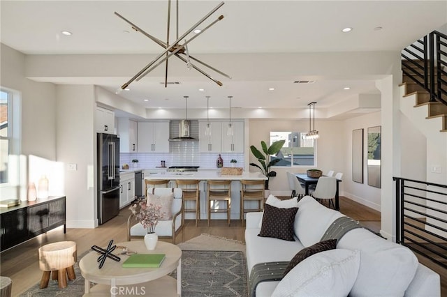 living room with light wood-type flooring and an inviting chandelier