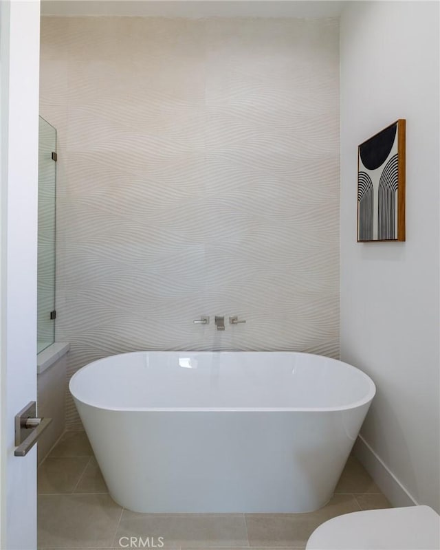 bathroom featuring tile patterned flooring and a tub to relax in